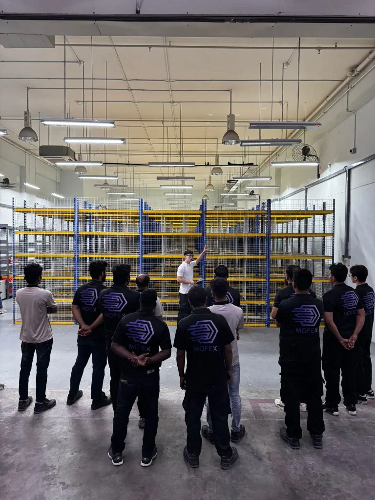 Mofex movers in branded uniforms at a warehouse site briefing