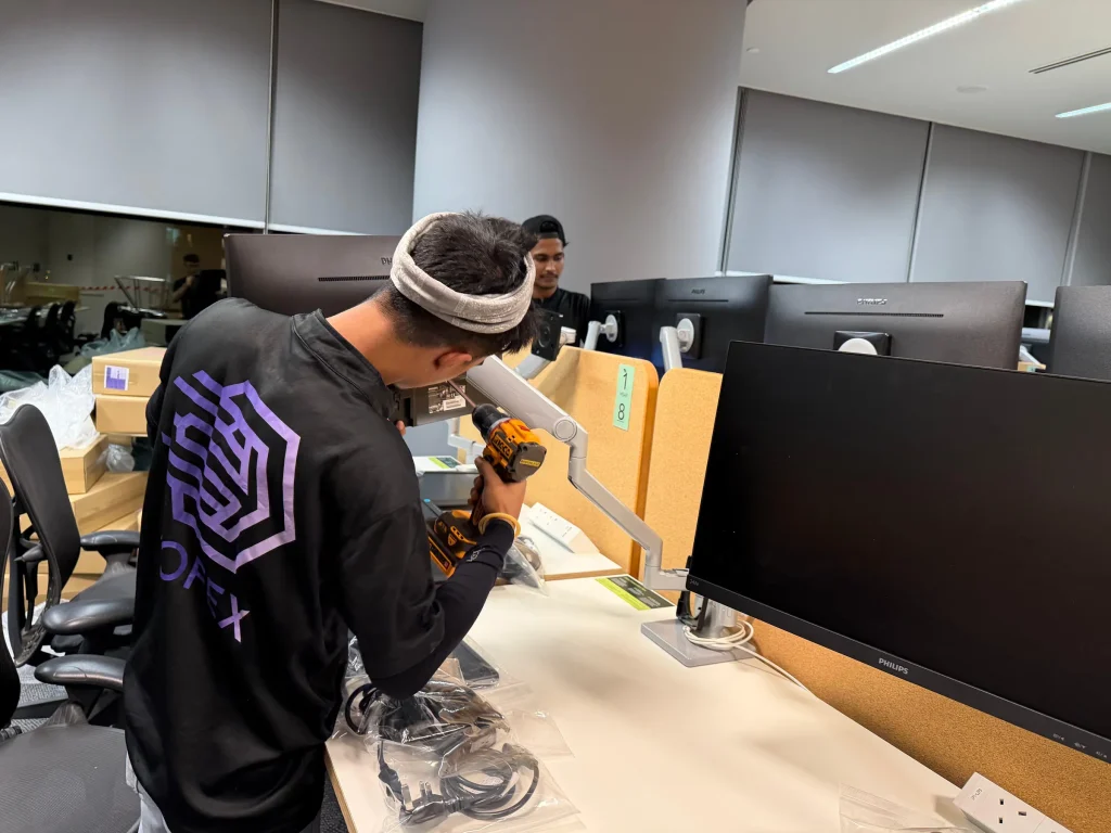 Mofex mover reassembling a workstation monitor arm with a power drill