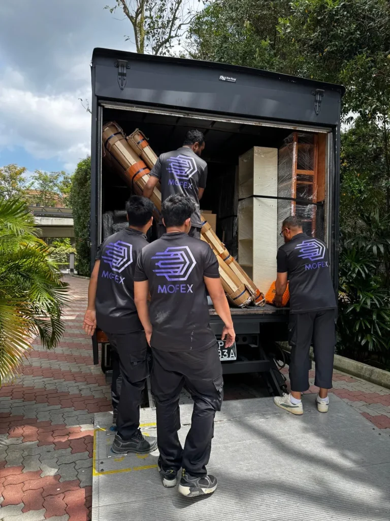 Mofex movers in branded shirts loading furniture into a lorry
